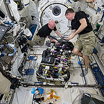ISS043E181459 (05/07/2015) – NASA astronauts Scott Kelly (left) and Terry Virts (right) work on a Carbon Dioxide Removal Assembly (CDRA) inside the station