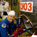 In the Integration Facility at the Baikonur Cosmodrome in Kazakhstan, Expedition 44 crew member Kjell Lindgren of NASA poses for pictures July 11 prior to entering his Soyuz TMA-17M spacecraft during a fit check dress rehearsal session. Lindgren, Oleg Kononenko of the Russian Federal Space Agency (Roscosmos) and Kimiya Yui of the Japan Aerospace Exploration Agency will launch July 23, Kazakh time from Baikonur in their Soyuz TMA-17M spacecraft for a five-month mission on the International Space Station. Credit: Gagarin Cosmonaut Training Center