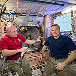 ISS043E198419 (05/15/2015) --- NASA astronauts Scott Kelly (left) and Terry Virts (right) share a snack while inside the station